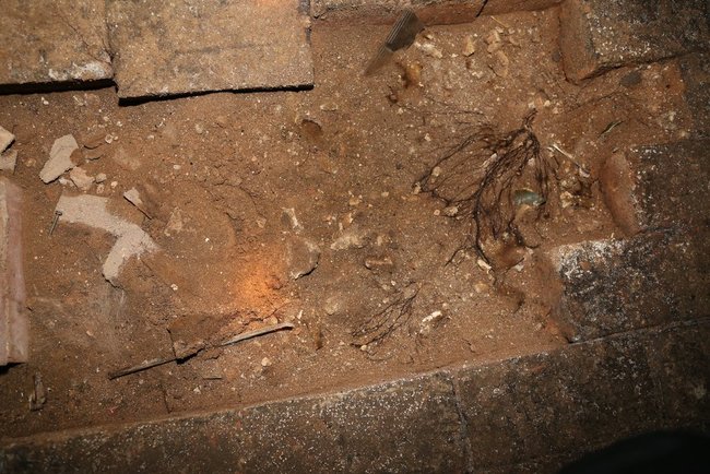 There was an opening in the middle of the floor with loose dirt in it. It seemed recently disturbed.