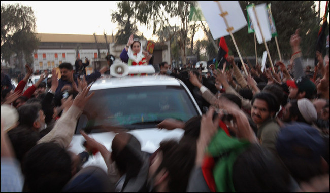 In the last known photo of Benazir Bhutto the Pakistani politiciancan be seen standing in the sunroof of her bullet proof vehicle wavingat the crowd. Seconds after this photo was taken a gunman fired shots ather and a bomb detonated next to the vehicle killing approximately 20people. Bhutto was critically wounded and rushed to the hospital whereshe died in surgery a few hours later.